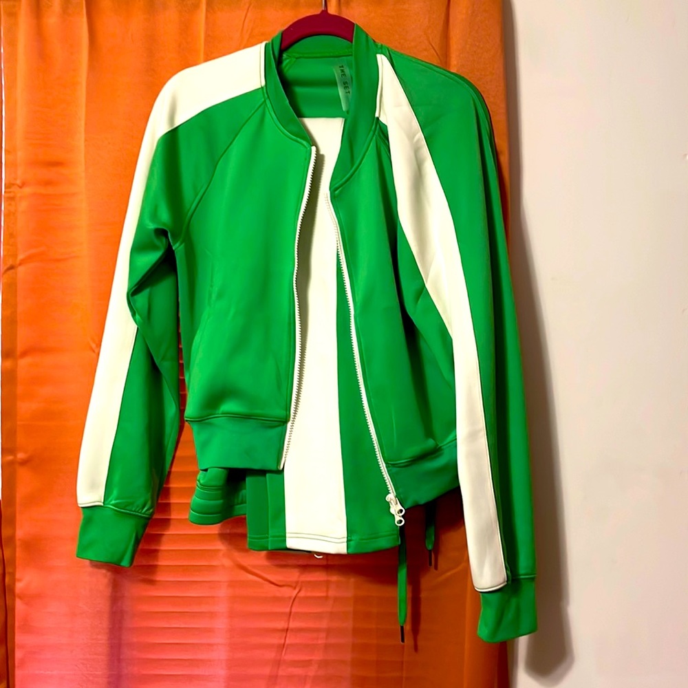 Green and white pant set with zipper pockets and zipper front of jacket